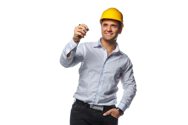 Smiling male in yellow safety helmet holding a pen. Isolated on a white background.