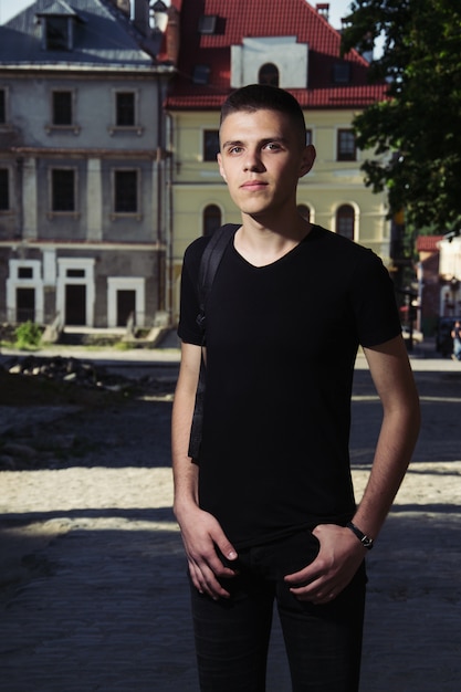 smiling man in black t-shirt over house