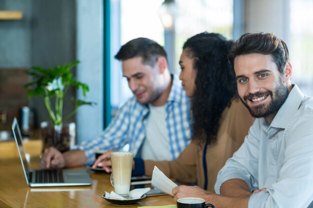 Smiling man in cafe with friends