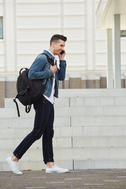 Premium Photo | Smiling man on cellphone walking outdoors]