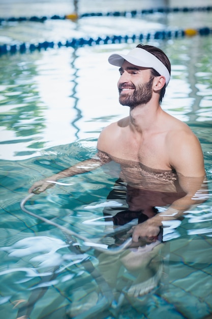 笑みを浮かべて男、プールで水中自転車をやっています。