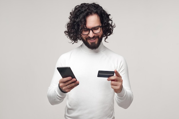 Smiling man entering credit card data on smartphone