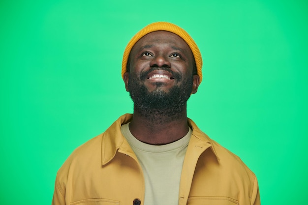 Smiling man in hat looking up