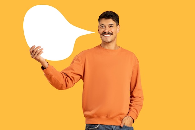 Smiling man holding a blank speech bubble