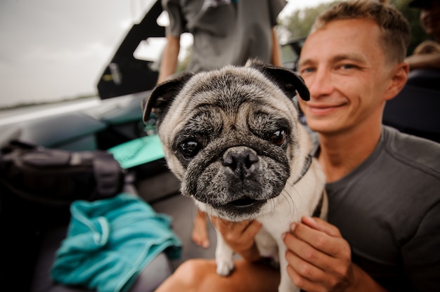 Smiling man holding at hands his cute puppy