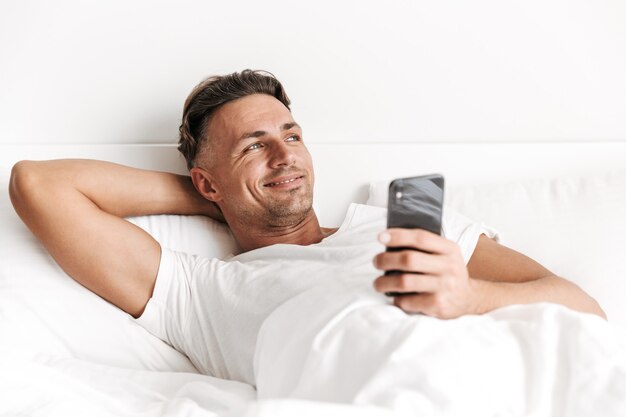 Uomo sorridente che tiene telefono cellulare