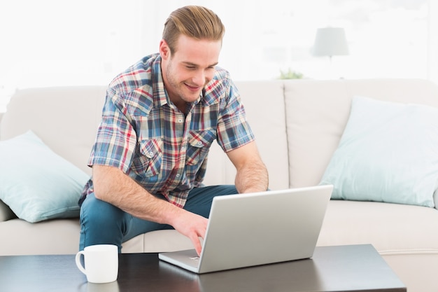 Smiling man at home on a laptop