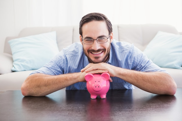 Smiling man laying on the piggy bank