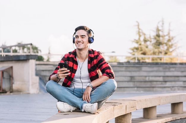 Фото Улыбающийся человек, слушая музыку на наушниках