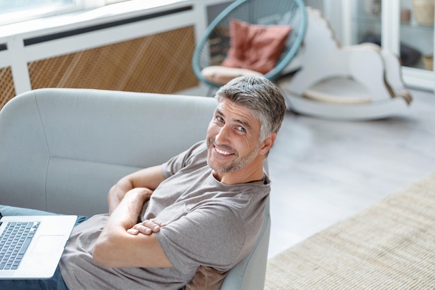 Smiling man looking at his laptop screen