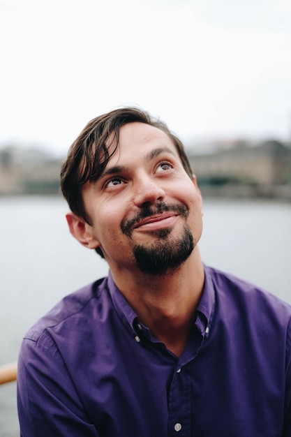 smiling man looking up against lake