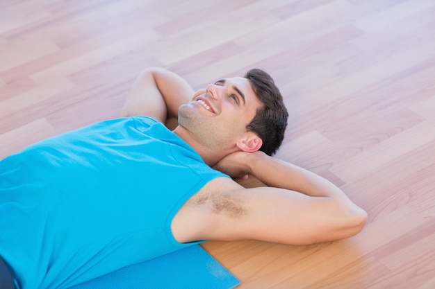 Smiling man lying on exercise mat 