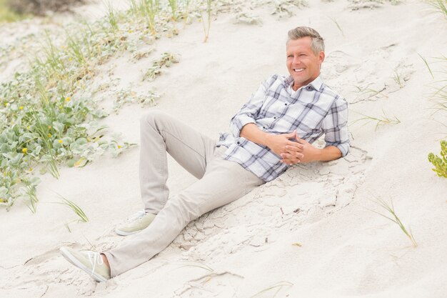 Smiling man lying on the sand