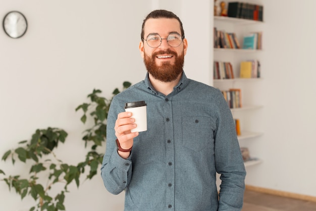 Улыбающийся человек офисный работник, держащий чашку кофе