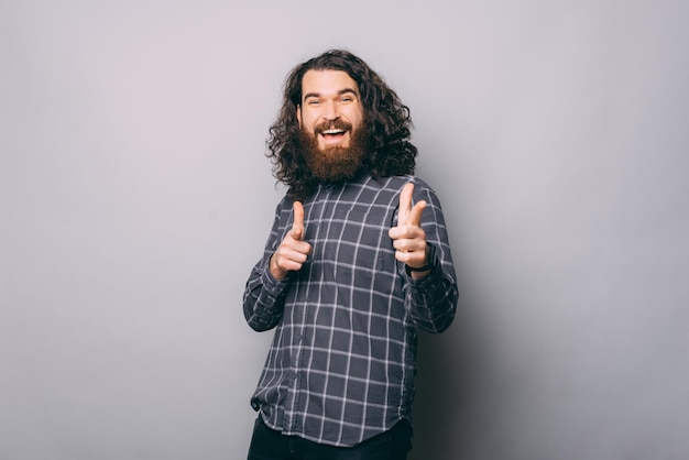 Smiling man pointing at camera