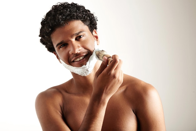 Smiling man puts foam for shave