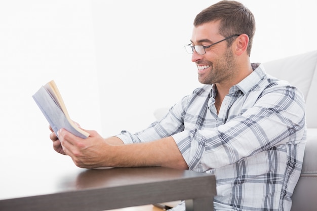 Photo a smiling man reading a book