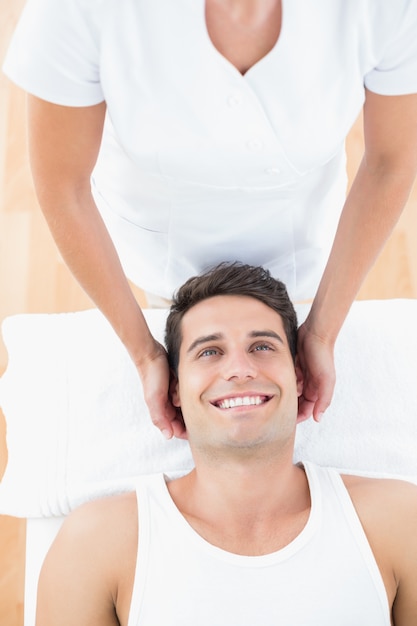 Smiling man receiving neck massage 