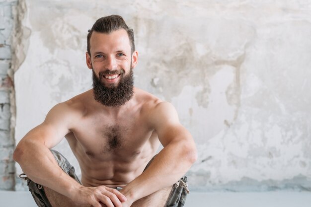 Smiling man sitting resting after workout. sport exercising and fitness lifestyle concept.