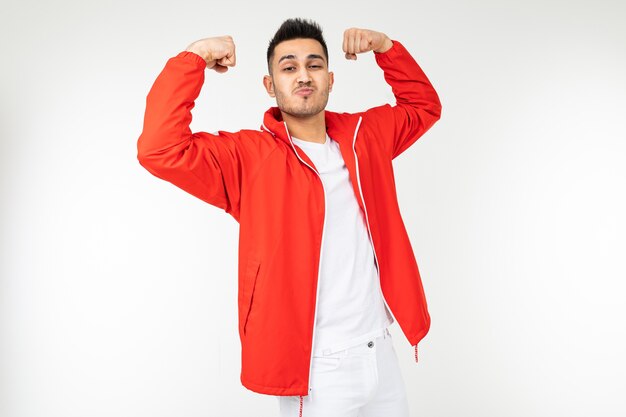 Smiling man in sports red shows off his strong muscles