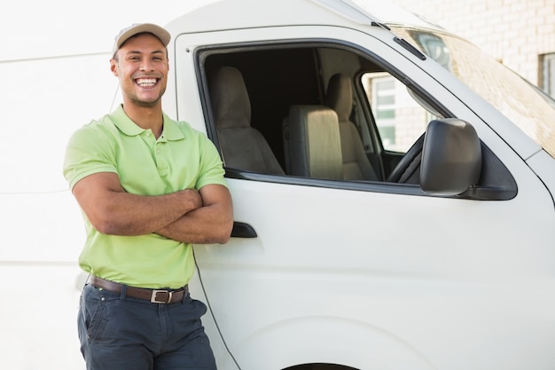 Smiling man standing against delivery van