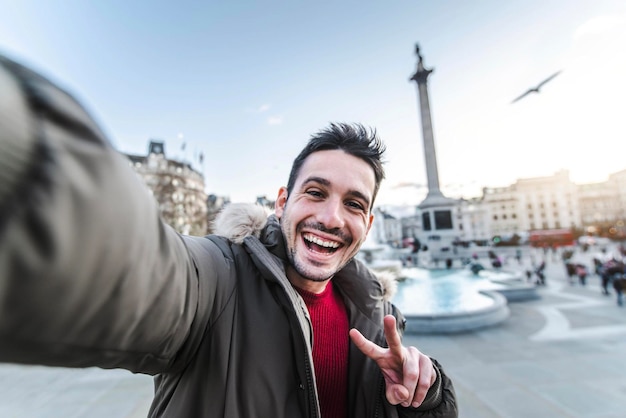 영국 런던에서 여행하는 동안 셀카 초상화를 찍는 웃는 남자