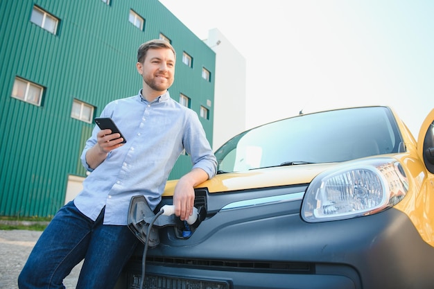 Smiling man unplugging the charger from the car