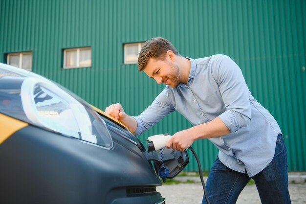 Smiling man unplugging the charger from the car