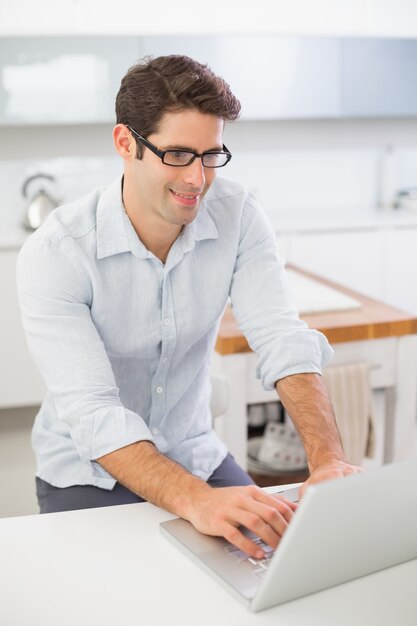 Smiling man using laptop at home