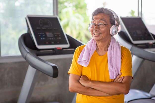 Photo smiling man with arms crossed standing in gym