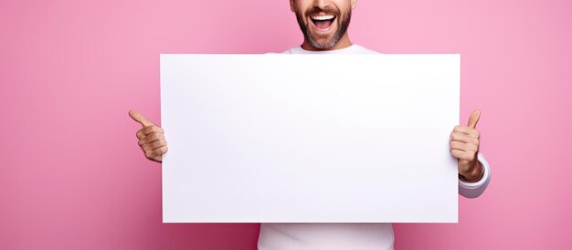 Photo smiling man with a beard stands by blank advertising board for text on pink background