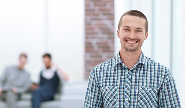 Uomo sorridente con una tavoletta digitale in piedi in ufficio. persone e tecnologia