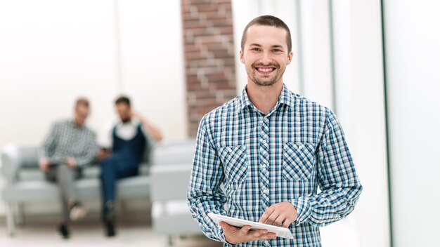 Smiling man with a digital tablet standing in the office