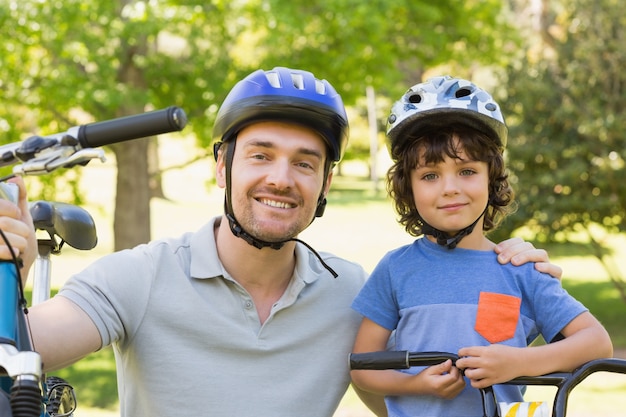 彼の息子が乗っている自転車で笑っている男