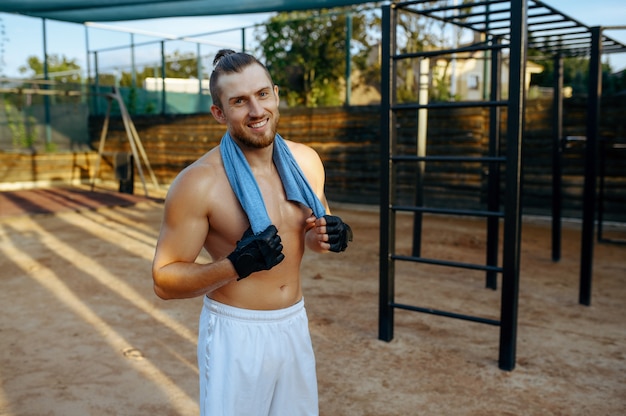 Smiling man with muscular body, street workout