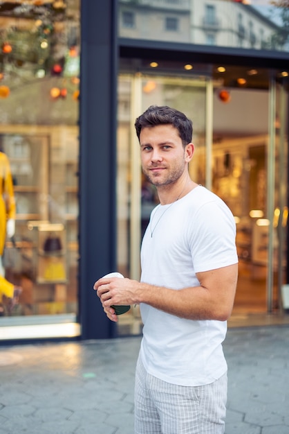 Smiling man with takeaway drink in city