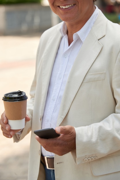 テイクアウトコーヒーと笑顔の男