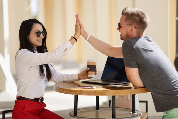 Smiling man and woman doing high five