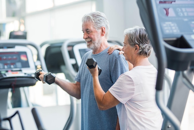 Photo smiling man and woman exercising in gym