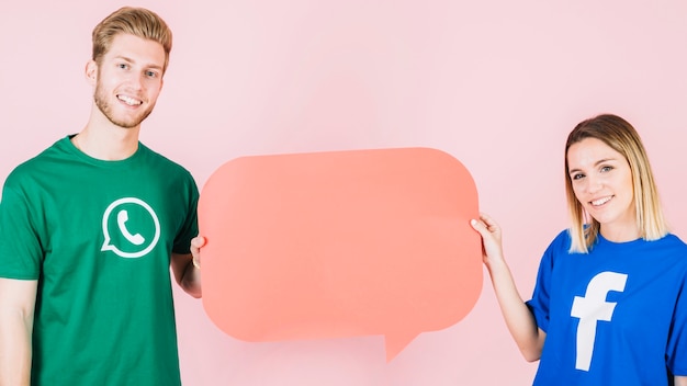 Photo smiling man and woman holding empty orange speech bubble