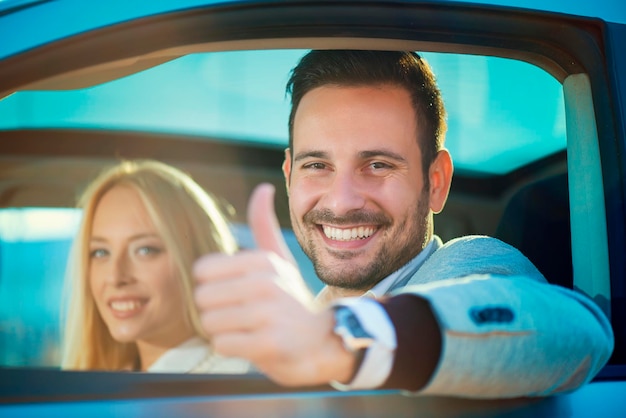 Smiling man and woman in a new car