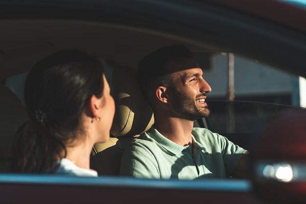 The smiling man and woman sitting in the car