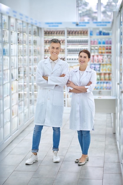 Smiling man and woman standing in pharmacy