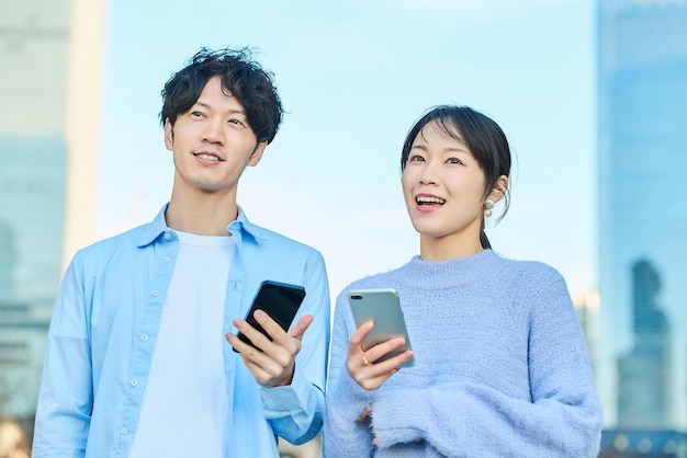 Foto uomo e donna sorridenti con lo smartphone in mano