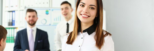 Smiling manager posing with colleagues in office stylish look for work