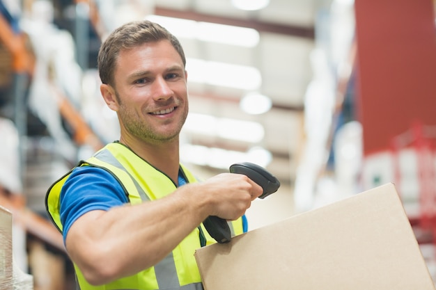 Smiling manual worker scanning package