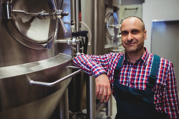 Smiling manufacturer standing at brewery