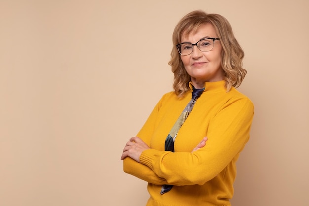 Smiling mature business woman in glasses with folded hands