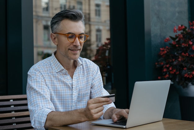 Smiling mature businessman holding credit card