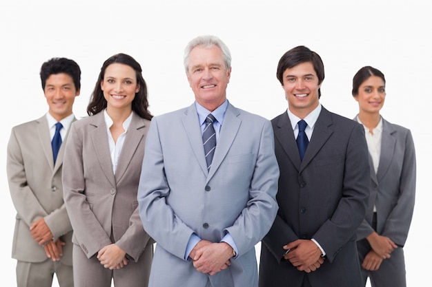 Smiling mature businessman standing with his team